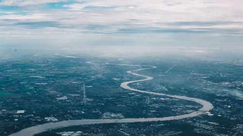 High angle view of road by cityscape against sky