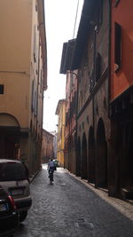 Rear view of man walking on street in city