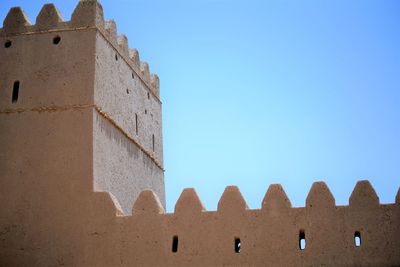 Low angle view of  ancient arabic fortress against clear blue sky