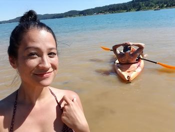 Portrait of smiling woman standing at beach 