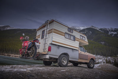 Camper truck with touring motorcycle in spray lakes reservoir