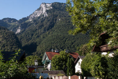 Houses by trees and mountains against sky