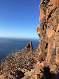 Rock formations in sea against sky