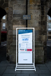 Information sign on footpath by building