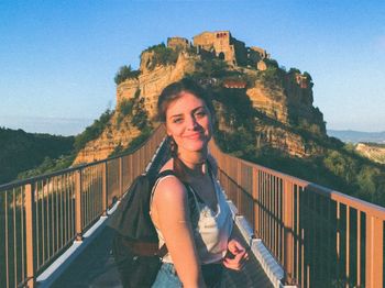 Portrait of smiling woman standing on bridge