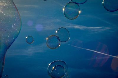 Close-up of bubbles against blue sky