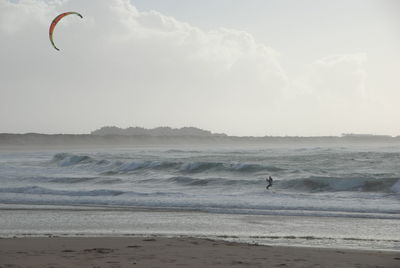 Man kiteboarding against sky