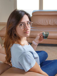 Portrait of young woman wearing sunglasses at home