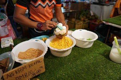 Midsection of man preparing food at market stall