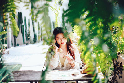 Portrait of young woman sitting on table