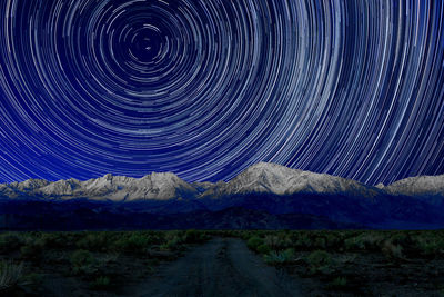 Scenic view of snowcapped mountains against sky at night