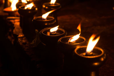 Close-up of lit diyas at night