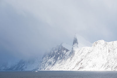 Scenic view of snowcapped mountains by sea against sky