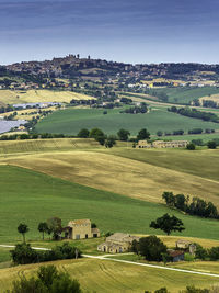 Scenic view of field and houses against sky