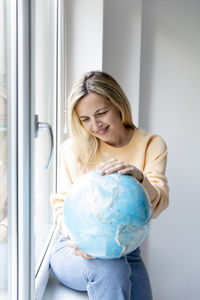 Portrait of cute girl with arms crossed at home