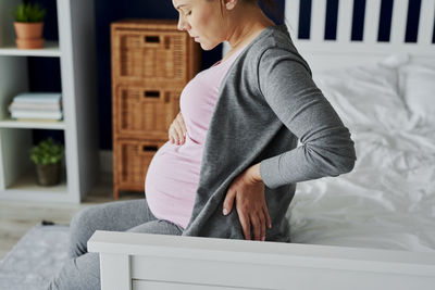 Side view of woman sitting at home