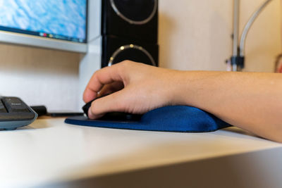 Cropped hand using computer mouse on table