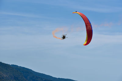 Low angle view of person paragliding in sky