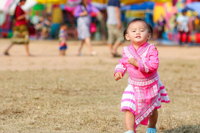 Full length of cute girl holding hands on field