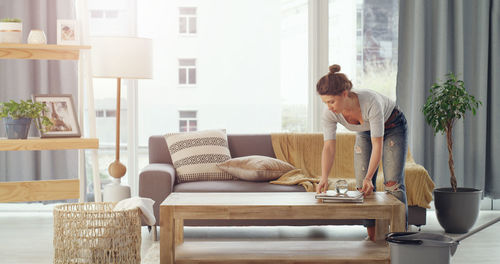 Side view of young woman using laptop at home