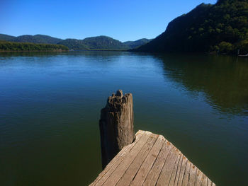 Wooden pier over lake against sky