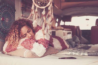 Close-up portrait of girl sitting on bed at home