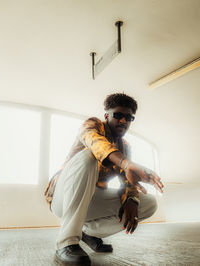 Portrait of young man standing against wall