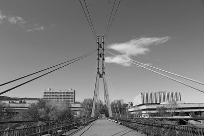 Low angle view of overhead cable cars against sky