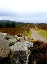 Rocks on field against sky