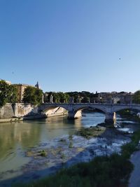 Bridge over river against clear blue sky