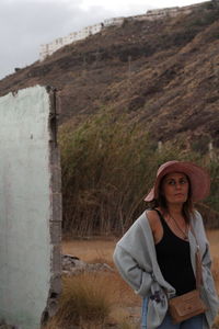 Portrait of beautiful woman standing against wall