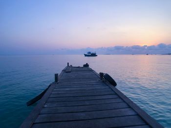 Pier over sea against sky during sunset