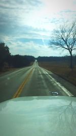 Empty road with trees in background