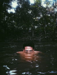 Portrait of young woman swimming in lake