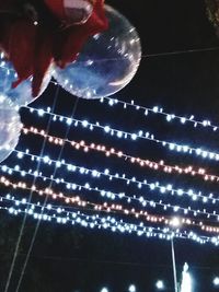 Low angle view of illuminated christmas lights at night