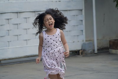 Girl shouting while running on footpath