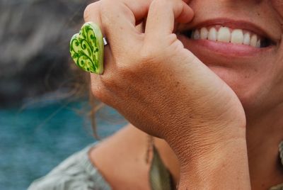 Close-up of woman wearing heart shape green ring outdoors