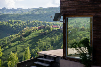 Scenic view of mountains against sky with a modern cabin in the front