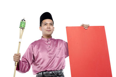 Portrait of young man standing against white background