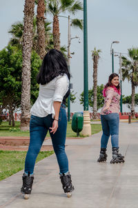 Rear view of women standing on footpath