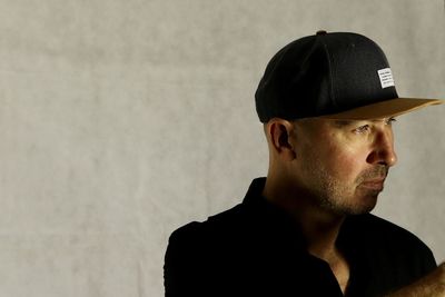 Close-up of thoughtful man wearing cap against wall