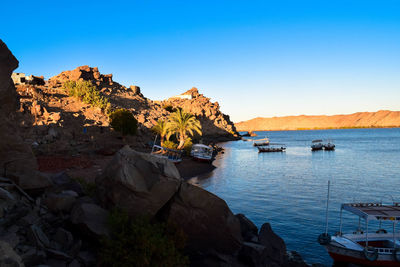 Scenic view of bay against clear blue sky