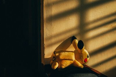 Stuffed toy on table against wall