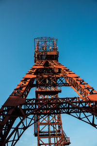 Low angle view of communications tower against blue sky