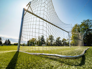 Look through net to football field in soccer stadium. soccer field with green grass in football