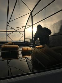 Man working in glass at sunset