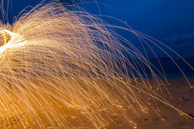 Firework display against blue sky