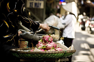 Midsection of person with bicycle selling dragon fruits