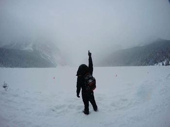 Full length of man standing on snow during foggy weather