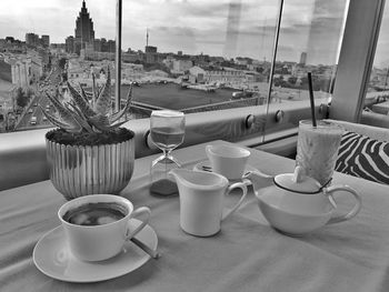 Coffee cup on table against cityscape
